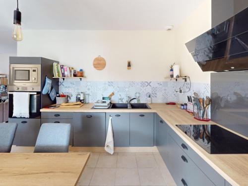 une cuisine avec un évier et un plan de travail dans l'établissement Maison spacieuse à Gigean avec jardin et terrasse, proche plages méditerranéennes - FR-1-785-22, à Gigean