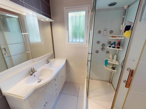 une salle de bain blanche avec une douche et un lavabo dans l'établissement Maison spacieuse à Gigean avec jardin et terrasse, proche plages méditerranéennes - FR-1-785-22, à Gigean
