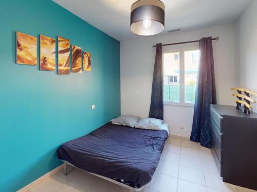 une chambre avec un lit avec un mur bleu dans l'établissement Maison spacieuse à Gigean avec jardin et terrasse, proche plages méditerranéennes - FR-1-785-22, à Gigean