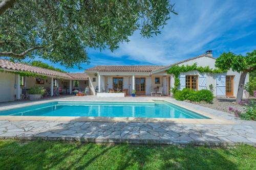 a villa with a swimming pool in front of a house at Le Bariole, luxury villa with heated pool in Cesseras
