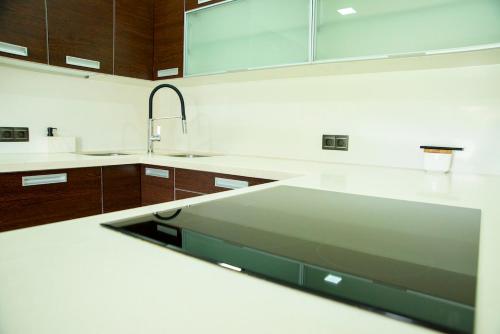 una cocina con encimeras blancas y armarios de madera en Welcome Villa O Sidrón, 