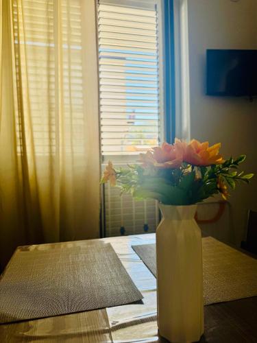 a vase filled with flowers sitting on a table at Affacciati sulle Eolie Appartamenti sul Lungomare Patti Marina in Patti