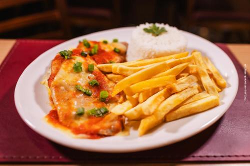 a plate of food with french fries and meat at Hotel Nacional Inn Araçatuba in Araçatuba