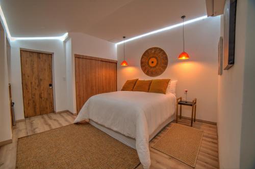 a bedroom with a white bed and a wooden door at Pao Pao Hotel Islas del rosario in Isla Grande