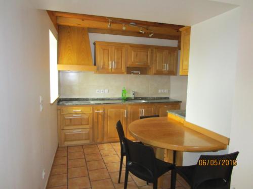 a kitchen with wooden cabinets and a wooden table and chairs at Etxexuriko Borda in Aïnhoa