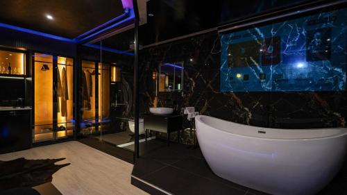 a bathroom with a white tub and a sink at 446 Black Suite Luxury in Shkodër