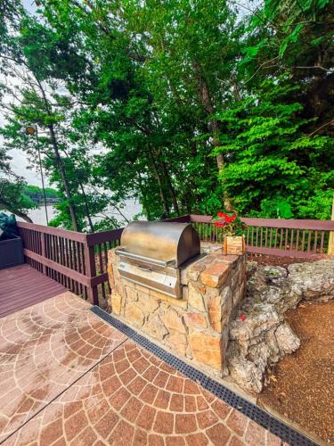 a stone fireplace on a patio with a wooden deck at Treetop Village-2bed2bathpoolsdock6-8pp in Four Seasons