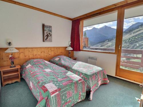 une chambre d'hôtel avec deux lits et une fenêtre dans l'établissement Appartement ensoleillé avec TV, proche pistes et commerces, Résidence Plein Soleil, Les Allues - FR-1-182-18, à Méribel