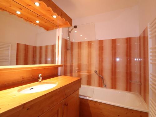 une salle de bain avec un lavabo et une baignoire dans l'établissement Appartement ensoleillé avec TV, proche pistes et commerces, Résidence Plein Soleil, Les Allues - FR-1-182-18, à Méribel