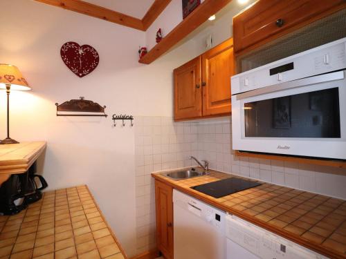 une cuisine avec un évier et un micro-ondes dans l'établissement Studio Cabine Cosy Plein Sud - Résidence Le Plein Soleil, Bord des Pistes, Proche Commerces - FR-1-182-16, à Méribel