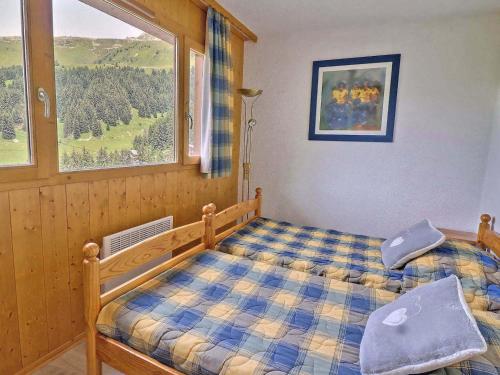 une chambre avec un lit et une grande fenêtre dans l'établissement Appartement 2 Pièces + Coin Montagne, Idéal Familles, au Pied des Pistes, Les Allues - FR-1-182-2, à Méribel