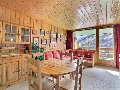 une salle à manger avec une table et un canapé dans l'établissement Appartement 5 pers, balcon sud, TV, Wi-Fi, kitchenette équipée - FR-1-182-19, à Méribel