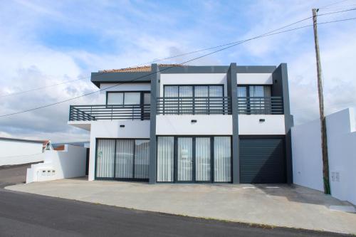 a large white building with a garage at Serena in Madalena