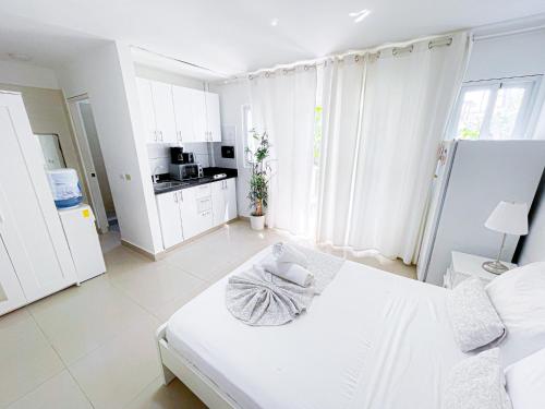 蓬塔卡纳CARIBBEAN Paradise TROPICAL HOTEL with VIEW Los Corales WiFi Beach CLUB & SPA的白色客房 - 带床和厨房