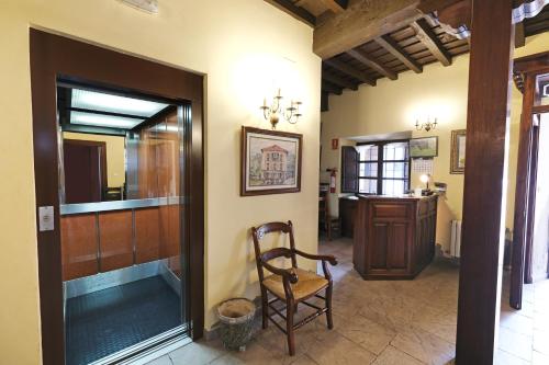 a hallway with a wooden door and a chair at Posada de Fidel in Puentenansa