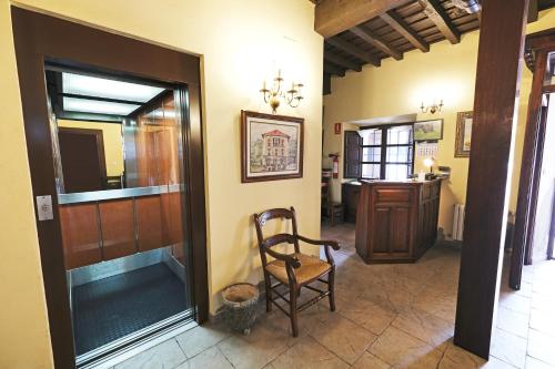 a hallway with a wooden chair in a room at Posada de Fidel in Puentenansa