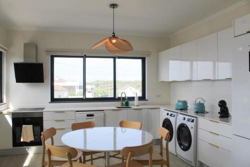 Una cocina con una mesa y sillas en una cocina. en Serena, en Madalena
