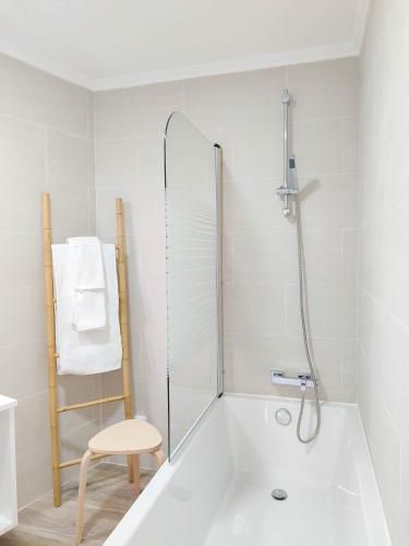a bathroom with a tub and a chair and a shower at Serena in Madalena
