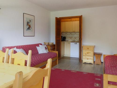 un salon avec un canapé rouge et une table dans l'établissement Méribel 2 Pièces, 5 Pers, Balcon Sud, Skis aux Pieds, TV, Wi-Fi, Non-Fumeur - FR-1-182-33, à Méribel