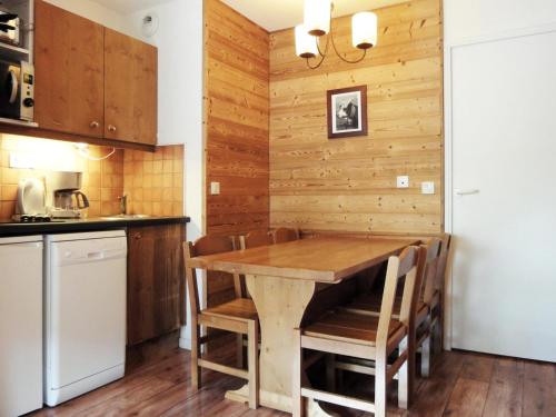 une cuisine avec une table et des chaises en bois dans l'établissement Duplex Châtelet avec Balcon, Proche Pistes et Commerces – Idéal Famille - FR-1-182-107, à Méribel