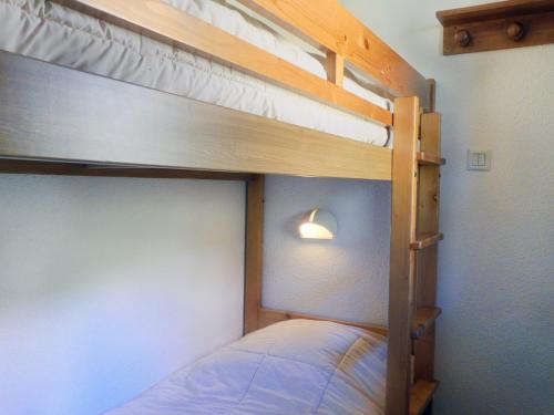 une chambre avec deux lits superposés et une lampe dans l'établissement Duplex Châtelet avec Balcon, Proche Pistes et Commerces – Idéal Famille - FR-1-182-107, à Méribel