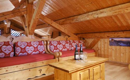 une pièce avec un canapé et des bouteilles de vin sur une table dans l'établissement Chez Merlin, à Glières-Val-de-Borne