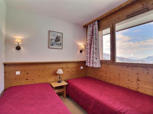une chambre avec deux lits et une fenêtre dans l'établissement Appartement de Charme 3* à Méribel, 2 Pièces, Animaux admis, Wi-Fi gratuit, 4 Pers - FR-1-182-41, à Méribel