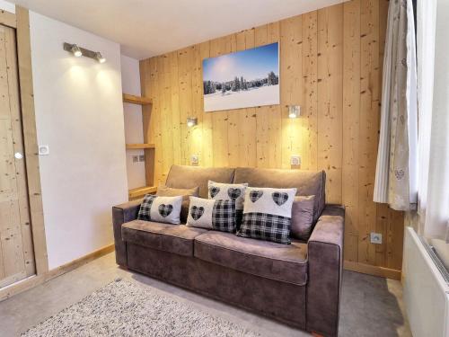 - un salon avec un canapé marron et des oreillers dans l'établissement Studio Divisible Idéalement Situé, Skis aux Pieds et Proche des Commerces - FR-1-182-194, à Les Allues