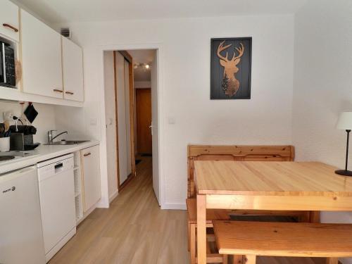 une cuisine et une salle à manger avec une table en bois dans l'établissement Studio cosy avec balcon, à deux pas des pistes et commerces au Châtelet - FR-1-182-86, à Méribel