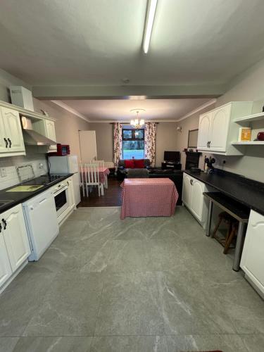 a kitchen with white cabinets and a living room at Reelin Bar Holiday Accommodation in Cloghan