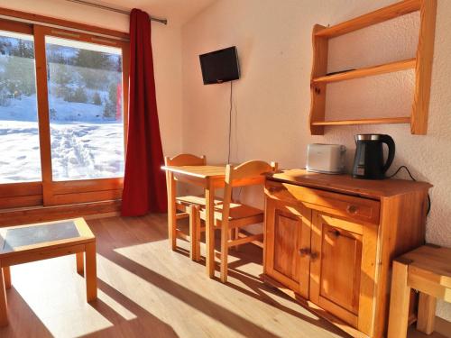 Cette chambre comprend un bureau, une table et une fenêtre. dans l'établissement Studio Lumineux au Pied des Pistes avec Terrasse Sud - FR-1-182-83, à Méribel