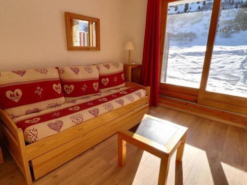 un salon avec un canapé et une fenêtre dans l'établissement Studio Lumineux au Pied des Pistes avec Terrasse Sud - FR-1-182-83, à Méribel