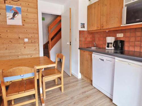 une petite cuisine avec une table en bois et une salle à manger dans l'établissement Charmant Duplex Skis aux Pieds, Proche Commerces, Méribel - FR-1-182-109, à Méribel