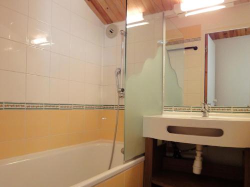 une salle de bain avec un lavabo, une baignoire et un miroir dans l'établissement Charmant Duplex Skis aux Pieds, Proche Commerces, Méribel - FR-1-182-109, à Méribel