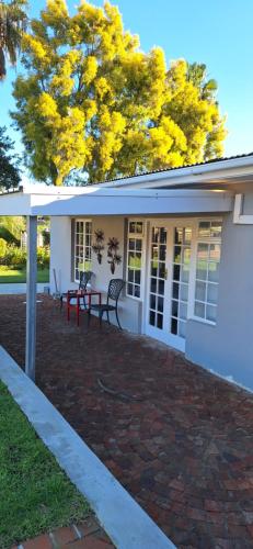 una casa con un banco rojo en un patio de ladrillo en Firehouse guest suite no 3, en Wellington