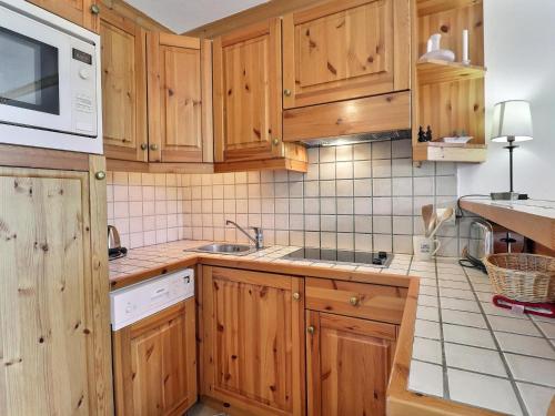 une cuisine avec des armoires en bois et un évier dans l'établissement Charmant 2 pièces 4 pers. - Méribel, balcon, Wi-Fi, non-fumeur - FR-1-182-190, à Méribel