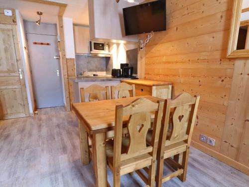 une cuisine et une salle à manger avec une table et des chaises en bois dans l'établissement Charmant 2 Pièces sur Les Pistes, Proche Commerces, Animaux Admis, 4 Personnes - FR-1-182-203, à Les Allues