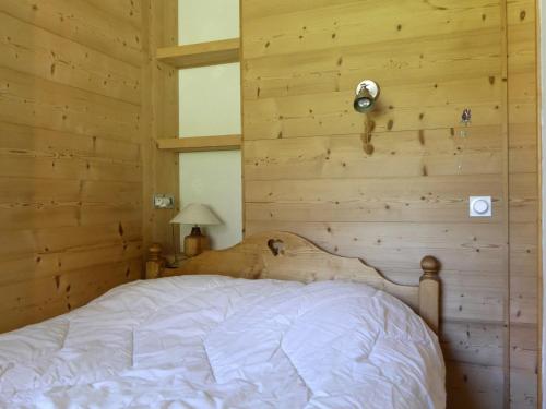 une chambre avec un lit dans un mur en bois dans l'établissement Charmant 2 Pièces sur Les Pistes, Proche Commerces, Animaux Admis, 4 Personnes - FR-1-182-203, à Les Allues