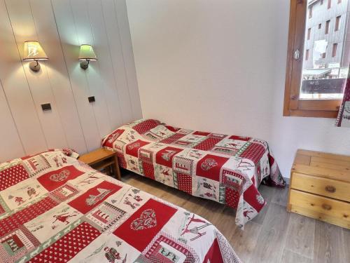 - 2 lits dans une chambre avec des couvertures de Noël dans l'établissement Appartement Idéalement Situé, Skis aux Pieds, Proche Commerces, 2 Pièces pour 4 Personnes - FR-1-182-230, à Les Allues