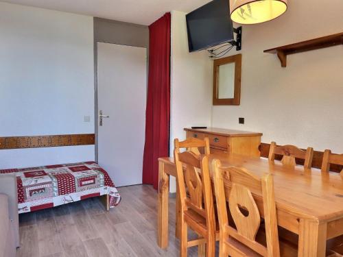 une salle à manger avec une table et des chaises en bois dans l'établissement Appartement Idéalement Situé, Skis aux Pieds, Proche Commerces, 2 Pièces pour 4 Personnes - FR-1-182-230, à Les Allues