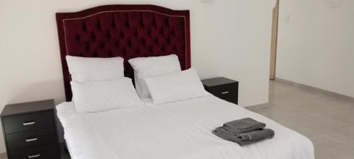 een slaapkamer met een bed met witte lakens en kussens bij Villa paradiso 1 in Centurion