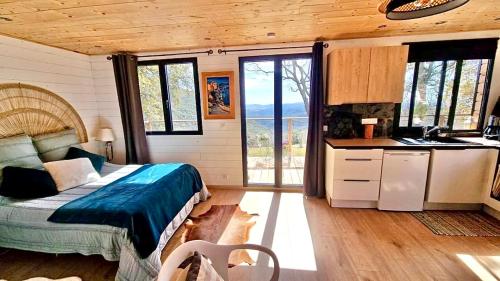 Cet appartement comprend une chambre avec un lit et une cuisine avec des fenêtres. dans l'établissement Roulotte et Tiny house, à Mons