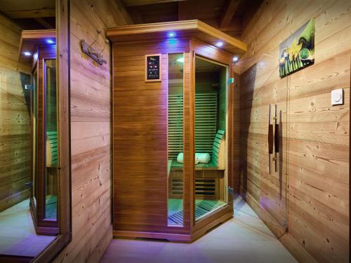 Cette chambre dispose de murs en bois et d'une douche à l'italienne. dans l'établissement Chalet La Canopée - OVO Network, à La Giettaz