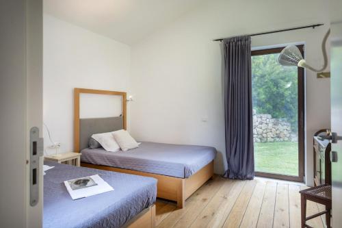 Un dormitorio con dos camas y una ventana. en Villa Talia 4 by Massimo Villas, en Cefalú