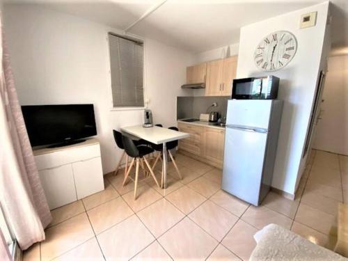Il comprend une cuisine équipée d'un réfrigérateur, d'une table et d'une horloge. dans l'établissement Le Désirade proche mer, à La Ciotat