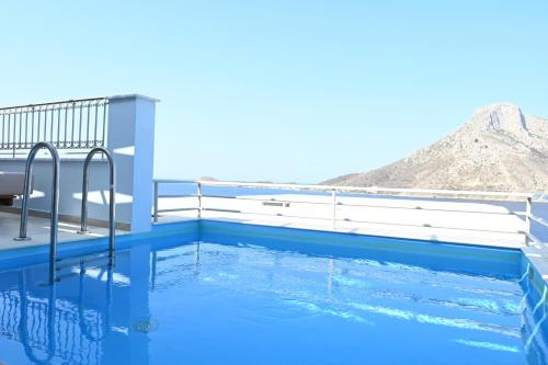 a swimming pool on the roof of a house with blue water at Elena Village Hotel & Suites in Kalymnos