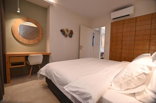 a bedroom with a bed and a table and a mirror at Elena Village Hotel & Suites in Kalymnos