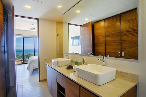 a bathroom with a sink and a large mirror at Alamar Vallarta vta in Cruz de Huanacaxtle