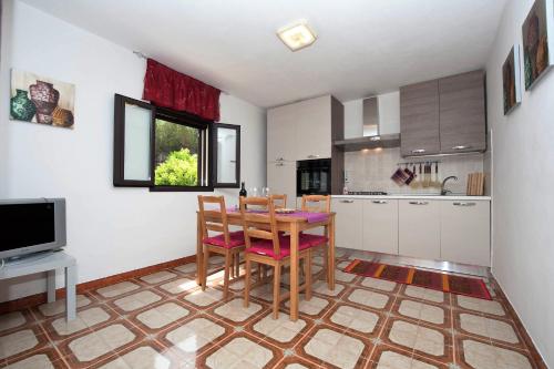 a kitchen with a table and chairs in a room at Anthiros Siracusa in Siracusa