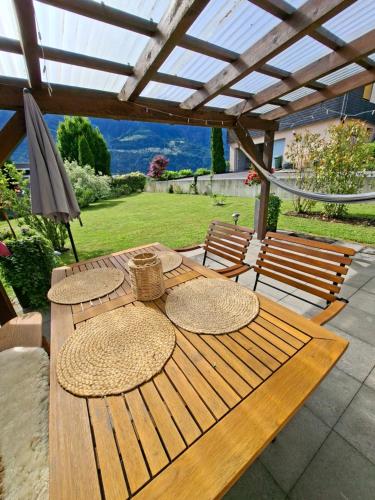 a wooden table with straw hats sitting on a patio at Garten-Wohnung in Eschen